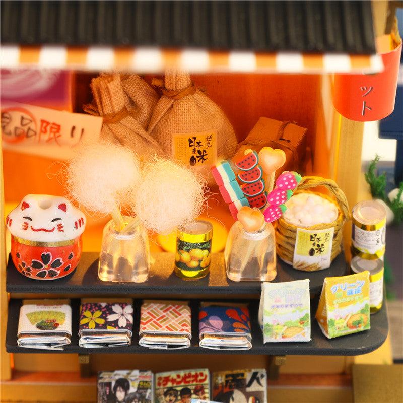Miniature market shelves stocked with tiny groceries and a lucky cat, a detailed Japanese shop kit for adult crafters