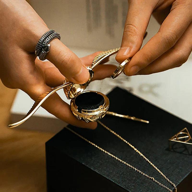 Gold plated snitch ring box opening in hand to show the velvet insert, a Harry Potter engagement gift for proposals RNGBX1