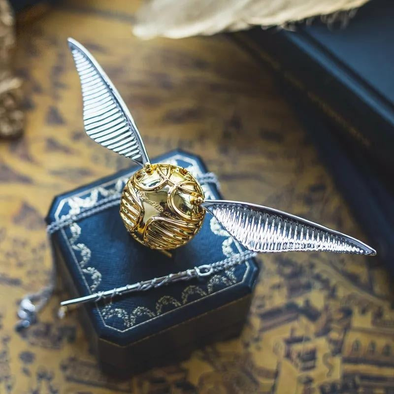 Silver winged snitch ring box with a wand key resting in a display case, a Harry Potter collector gift for weddings RNGBX2