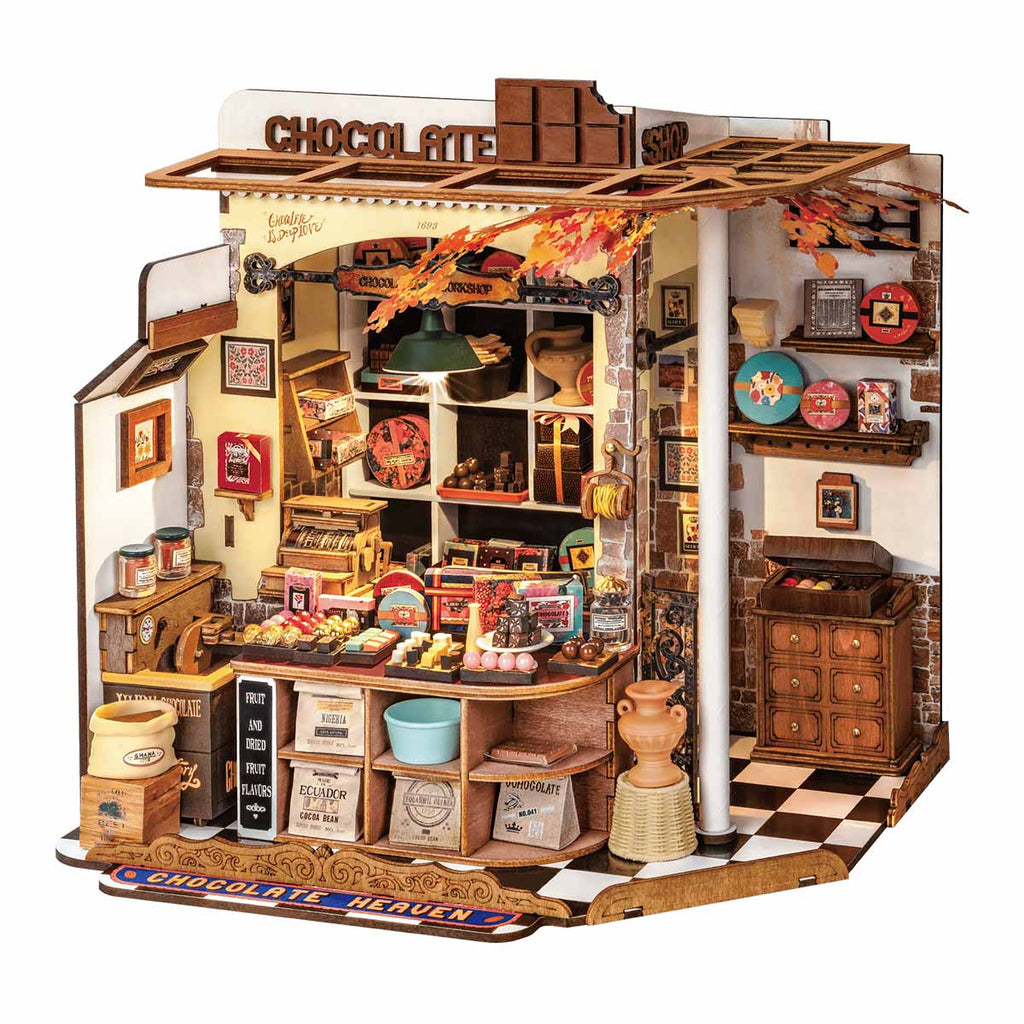 Finished miniature chocolate shop model with a wooden counter, vintage cash register and warm LED lit sweet displays for adults