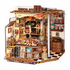 Finished miniature chocolate shop model with a wooden counter, vintage cash register and warm LED lit sweet displays for adults