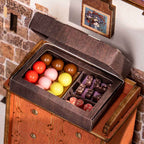 Open chocolate gift box with colorful bonbons and candy bars on a wooden cabinet inside a 1:18 scale miniature sweet shop model