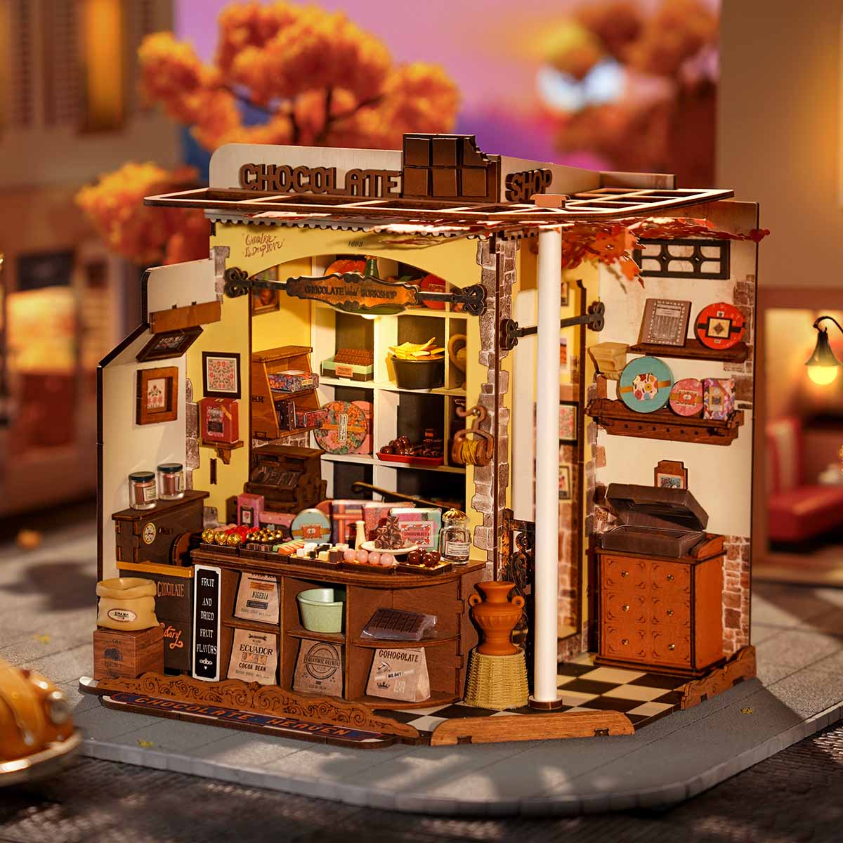 Miniature chocolate shop kit glowing with warm LED lights at dusk, a cozy display piece for a shelf or desk and a gift for adults