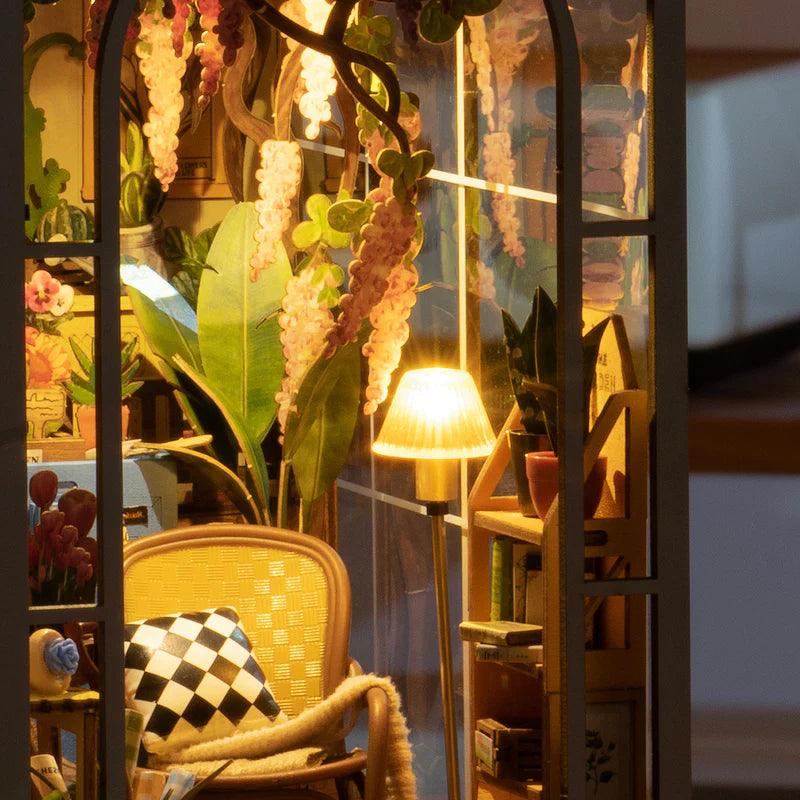 Touch activated warm LED lighting brings this miniature garden house to life as a cozy glowing shelf display
