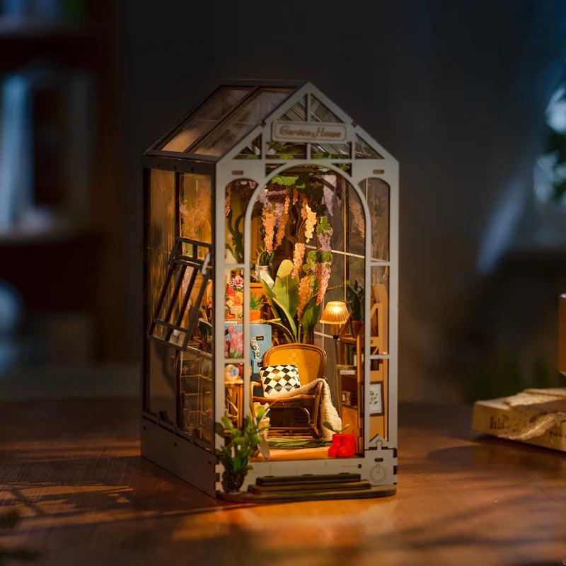 Miniature garden house featuring an arched door, ribbed glass, and a curved staircase for detailed shelf decor