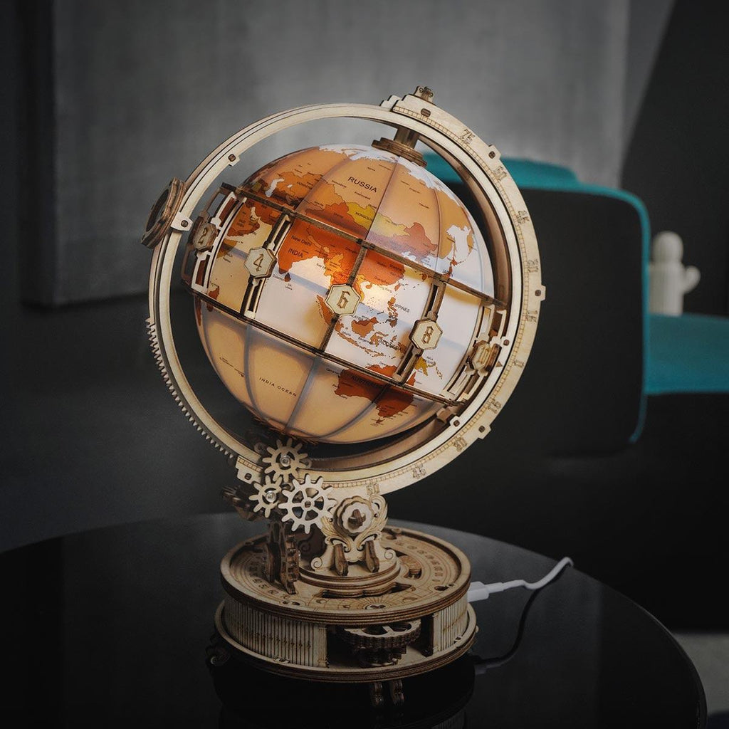 Wooden world globe puzzle lamp casting a soft warm glow as ambient desk decor for adult hobby builders and collectors