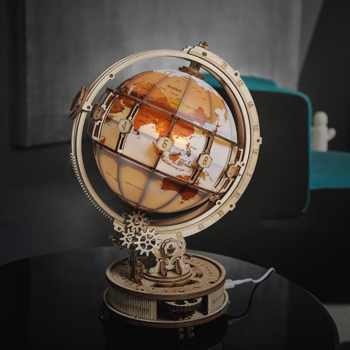Wooden world globe puzzle lamp casting a soft warm glow as ambient desk decor for adult hobby builders and collectors