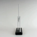 Kinetic energy sculpture with two balanced aluminum arms and a solid Black base, engineering desk art for a home office
