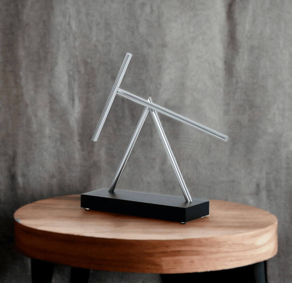 Swinging sticks kinetic sculpture as modern office decor and a conference table centerpiece on a Black display base
