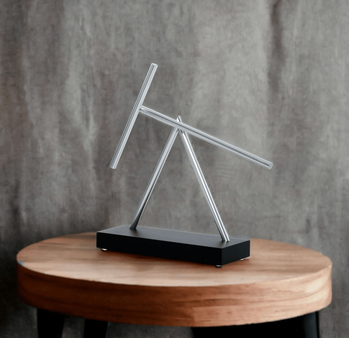 Swinging sticks kinetic sculpture as modern office decor and a conference table centerpiece on a Black display base
