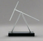 Perpetual motion swinging sticks sculpture driven by a whisper quiet electromagnetic base, a Black kinetic desk toy for offices