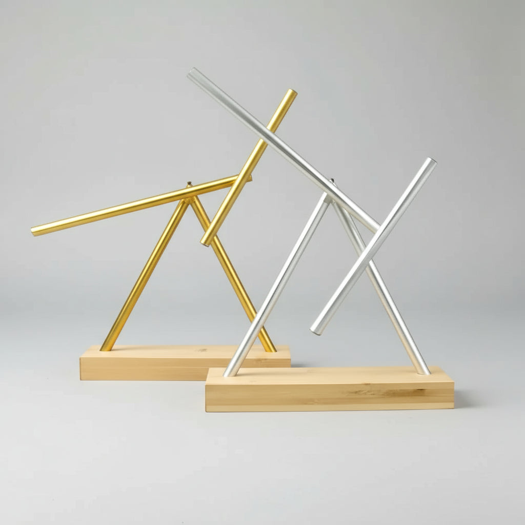 Kinetic swinging sticks sculptures in Gold and Silver finishes on wood bases, collector desk toys with hypnotic motion