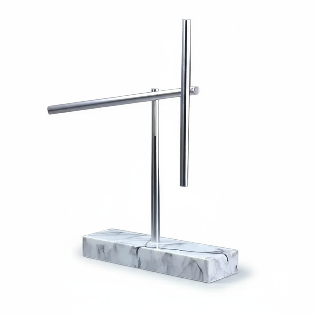 Kinetic energy desk sculpture with aluminum arms at rest on a White marble base, executive desk art for a home study