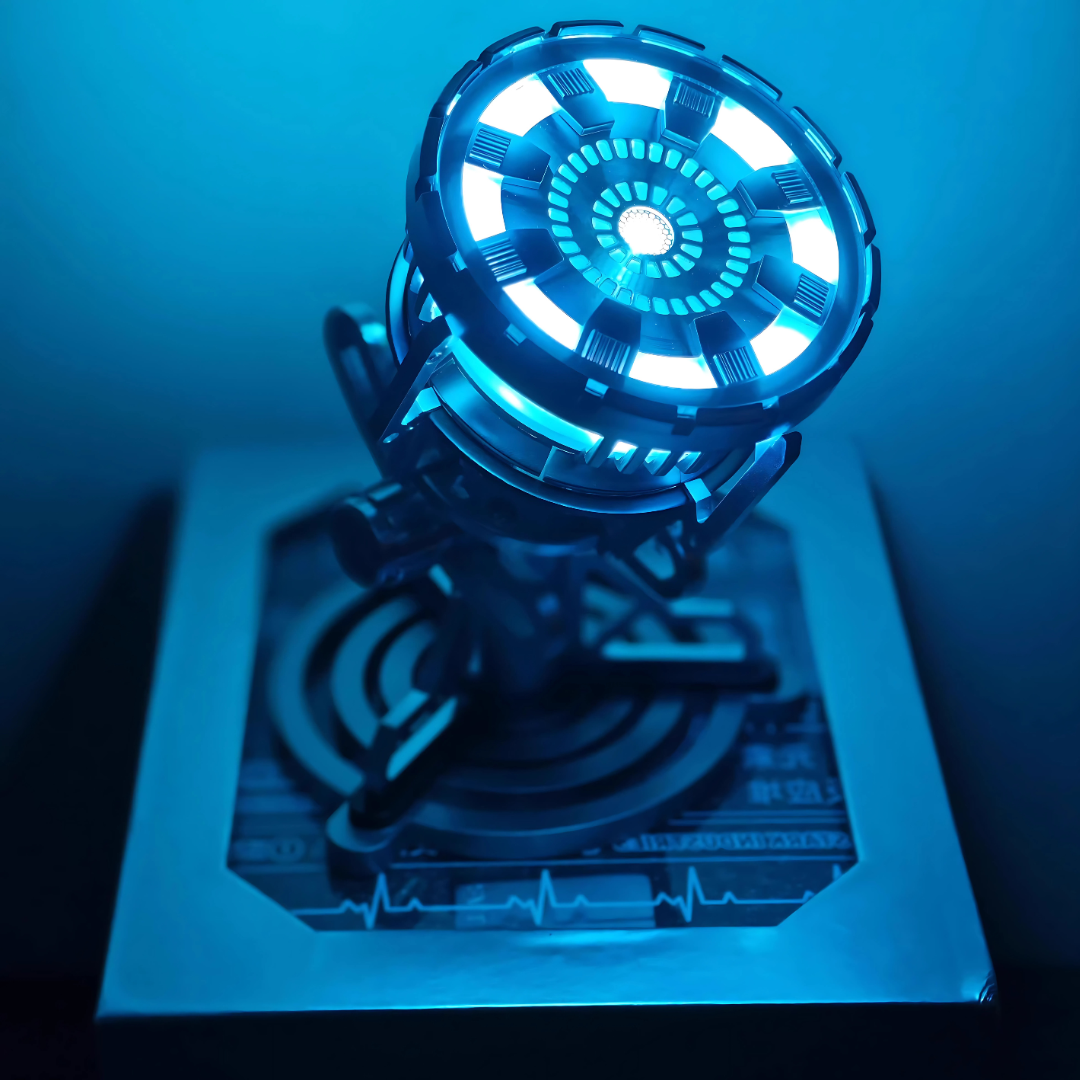 Illuminated arc reactor face with concentric blue LED rings, a Tony Stark chest lamp replica and ambient night light for a desk