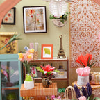 Miniature florist decor with framed botanical prints, tiny vases, and blooms, a handcrafted room box diorama for shelves