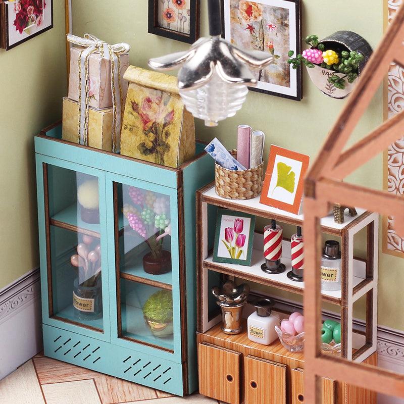 Miniature flower shop glass cabinet with hyacinths and wrapped floral gifts, a warm LED lit dollhouse kit for collectors