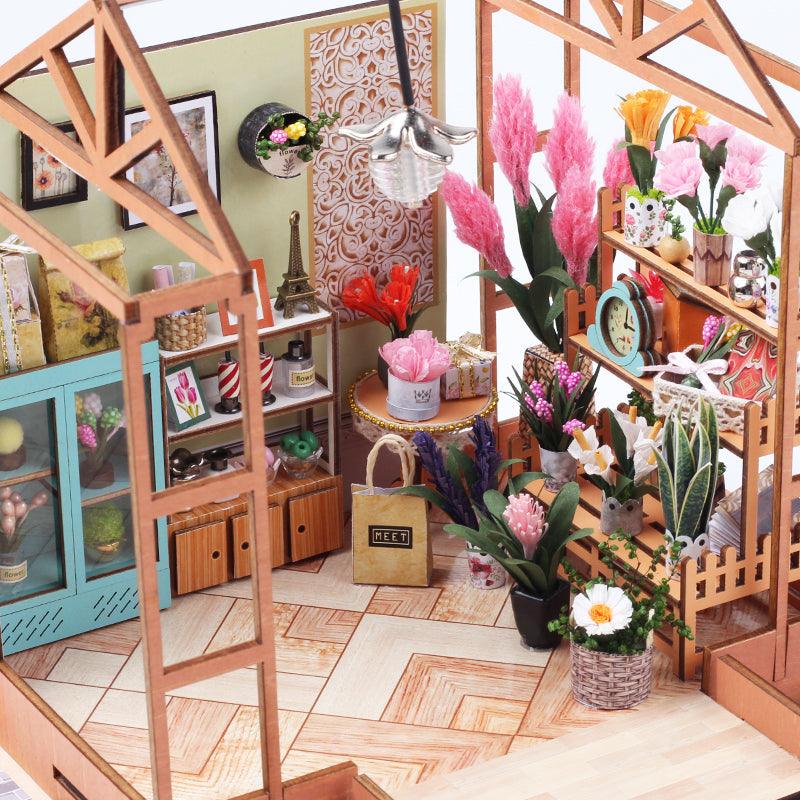 Miniature wooden greenhouse frame with tiered flower shelves and pampas blooms, a LED lit florist dollhouse desk decor