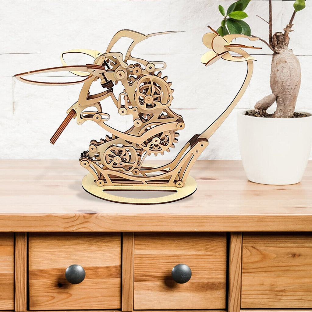 Kinetic wooden hummingbird sculpture with cams and linkages on a sideboard, mechanical model kit for DIY fans