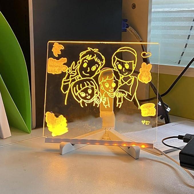 Light up LED drawing board for kids glowing with a colorful family doodle on an adjustable stand for screen-free art