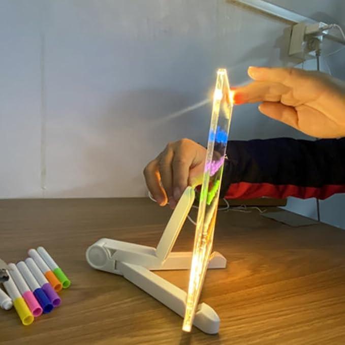 Child drawing on a luminous erasable board with a neon marker, a hands-on light up activity toy for the playroom