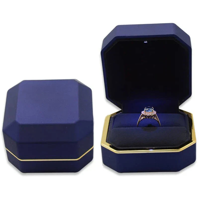 Blue octagonal LED engagement ring box with gold trim and a lit velvet cushion for a romantic proposal moment A-Blue