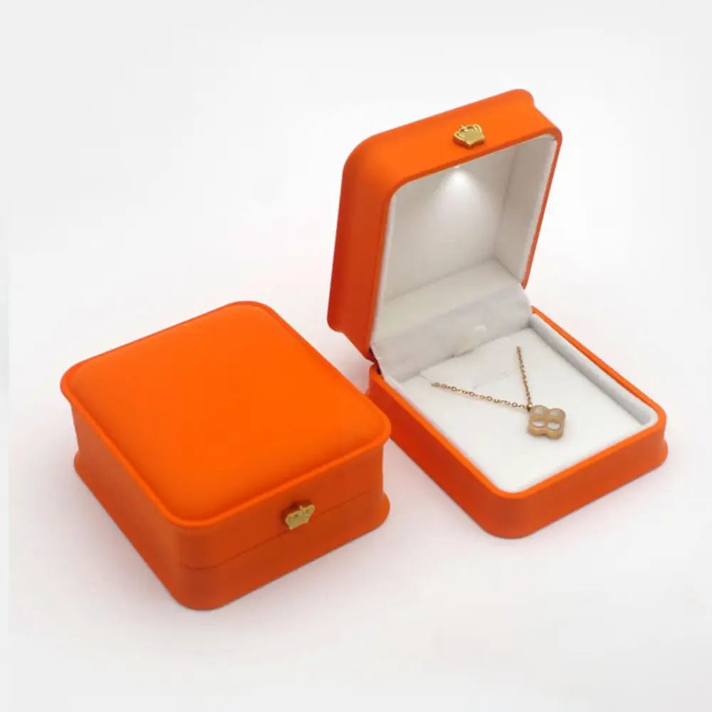Orange LED gift box with a lit interior holding a clover pendant necklace for a birthday jewelry gift for her E-Orange-Necklace