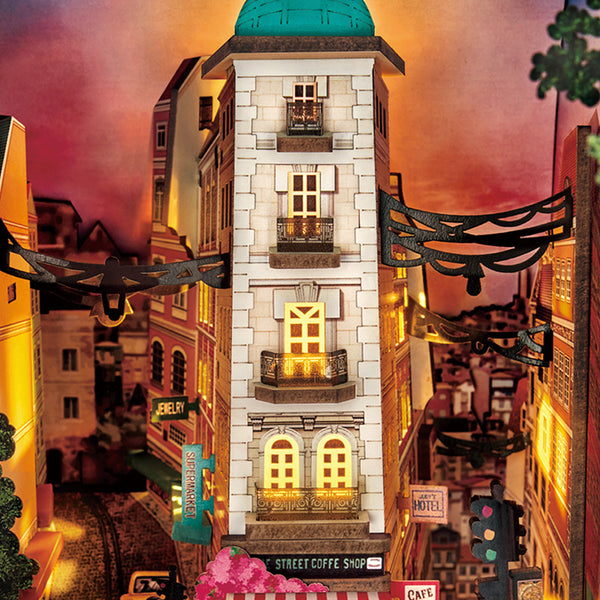 Night mode book nook diorama with cool toned LED street lamps lighting the miniature city buildings and street signs