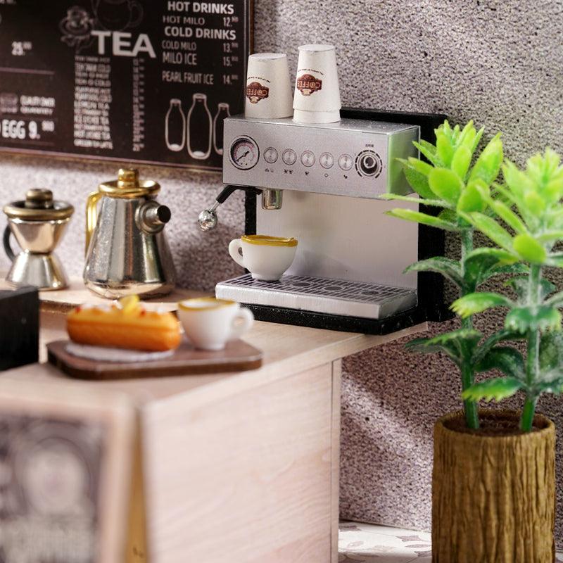 Miniature espresso machine with takeaway cups, a gold kettle and coffee grinder, a barista corner feature for hobby model builders