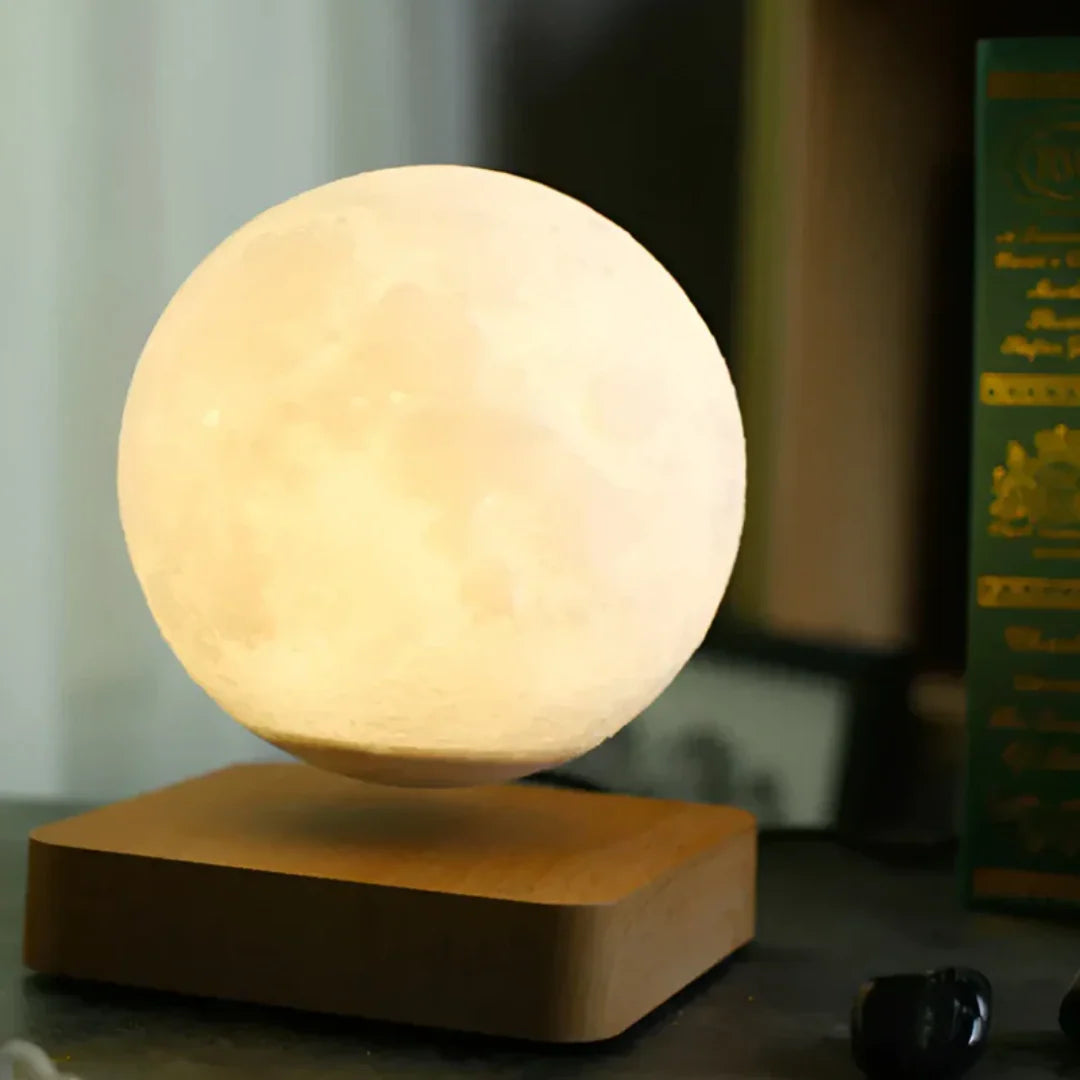 Warm white levitating moon lamp floating on a wooden base as a cozy desk night light and gift for space lovers
