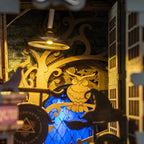 Ornate golden owl archway and hanging lantern glowing over a blue stained glass window in the fantasy book nook kit