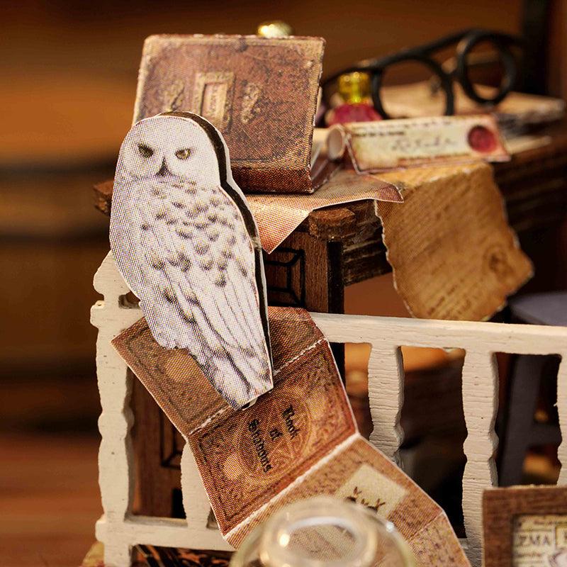 Magic House miniature dollhouse kit with perched owl figurine and antique storybooks, a whimsical illuminated model for crafters