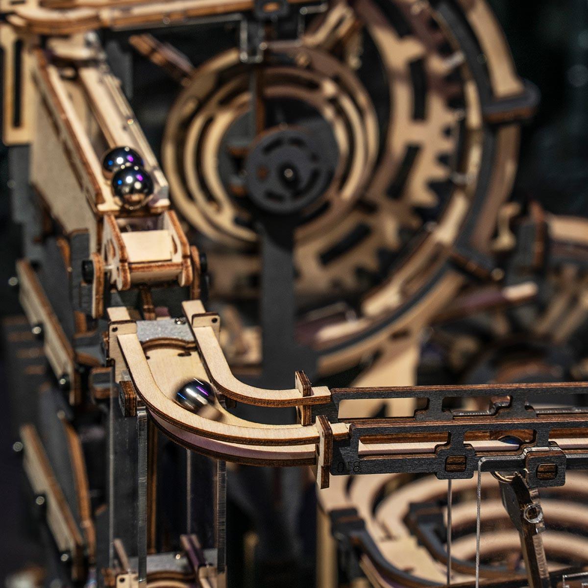 Steel marbles racing a 2.5 meter wooden track past spinning wheels, a physics and gravity STEM toy for teens