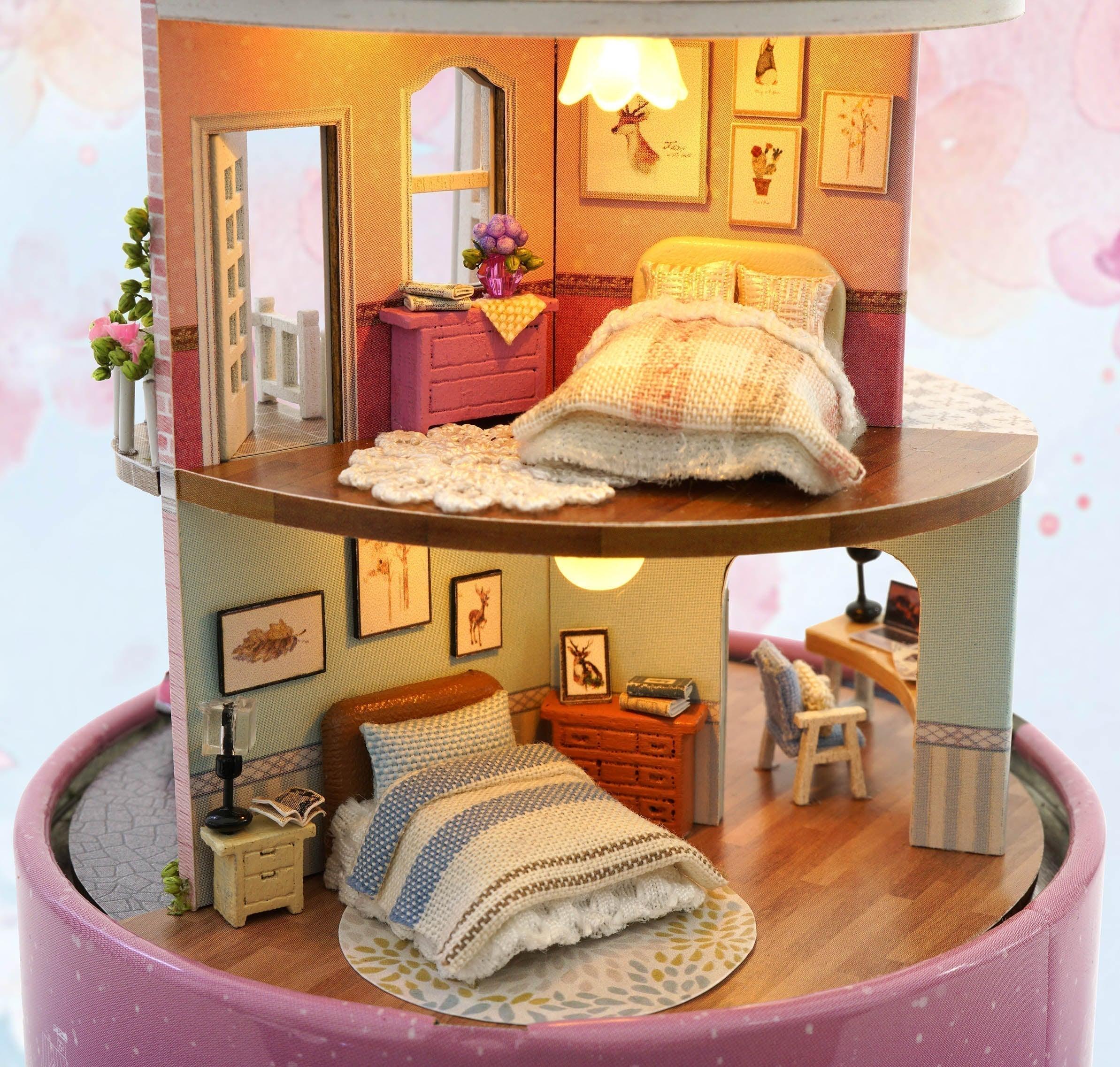 Three furnished floors of a miniature dollhouse kit with a cozy bedroom and a mint green living room study for adults