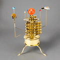 3D metal orrery solar system model kit with all eight planets orbiting a brass sun, a mechanical astronomy desk display