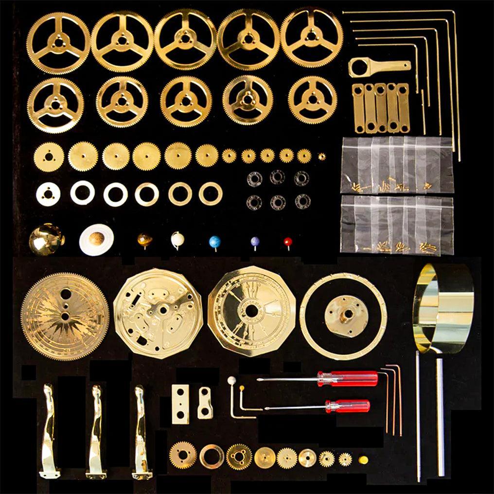 200 piece brass orrery kit laid out before assembly, a build it yourself solar system model and gift for science lovers