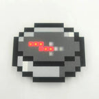 Portable Minecraft compass for camping and outdoor navigation with a red LED needle and pixelated cube design