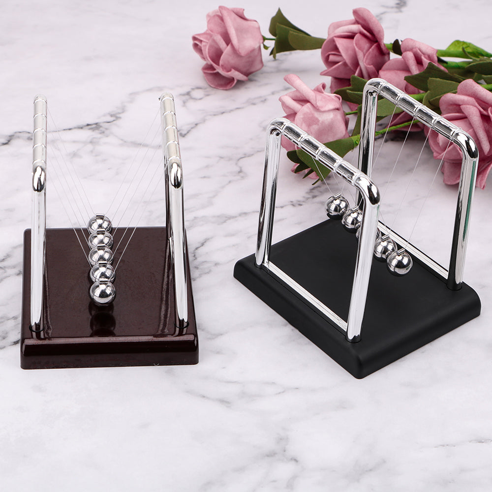 Newton's cradle desk toy shown in both black and red base finishes with polished steel balls for home or office decor (fits SKU_1748792312012_64, SKU_1748792312012_490)