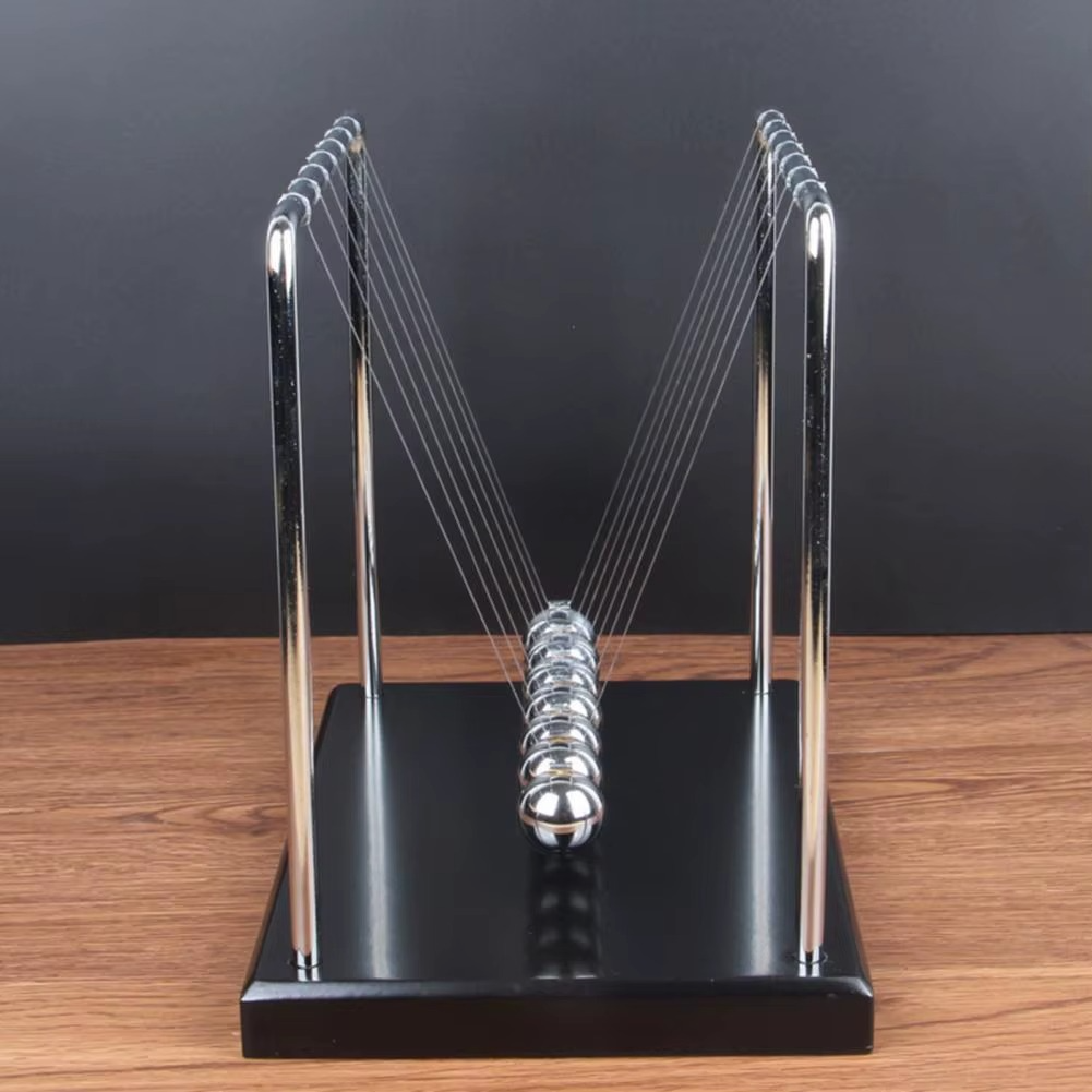 Newton's cradle in motion with steel balls mid swing on a black base showing energy transfer and Newton's third law (fits SKU_1748792312012_490, SKU_1748792312012_491)