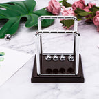 Newton's cradle with a red base styled on marble as an elegant science gift and reception desk decor piece for an office (fits SKU_1748792312012_64)