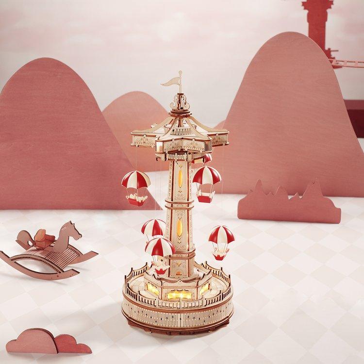 Glowing wooden music box that plays a melody, a rising parachute ride model and centerpiece for music box collectors