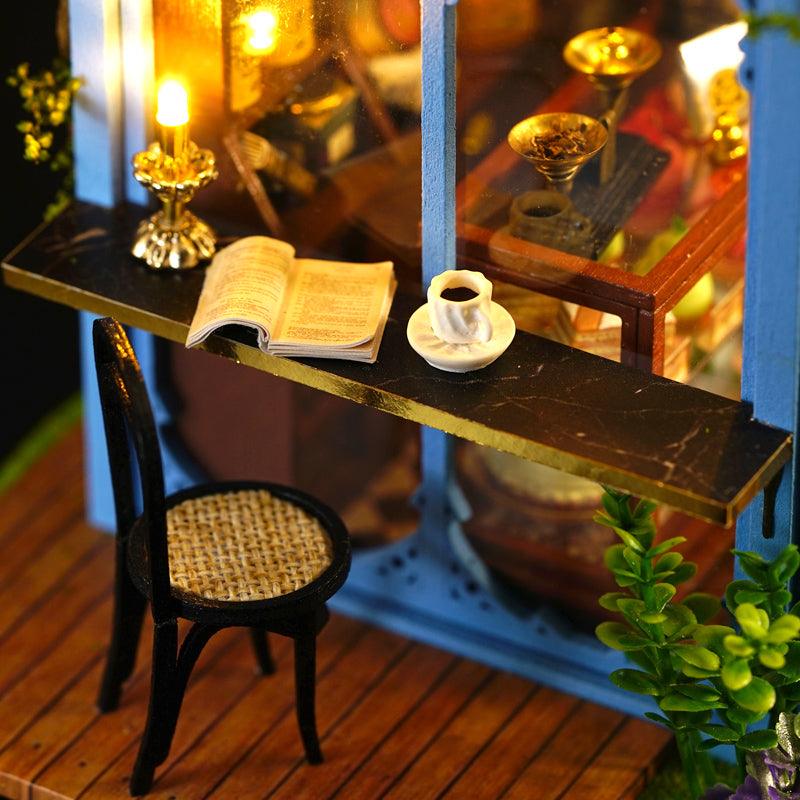 Warm LED lit tea house reading nook with bentwood chair, marble bar counter, and glass cabinet in 1:24 scale decor