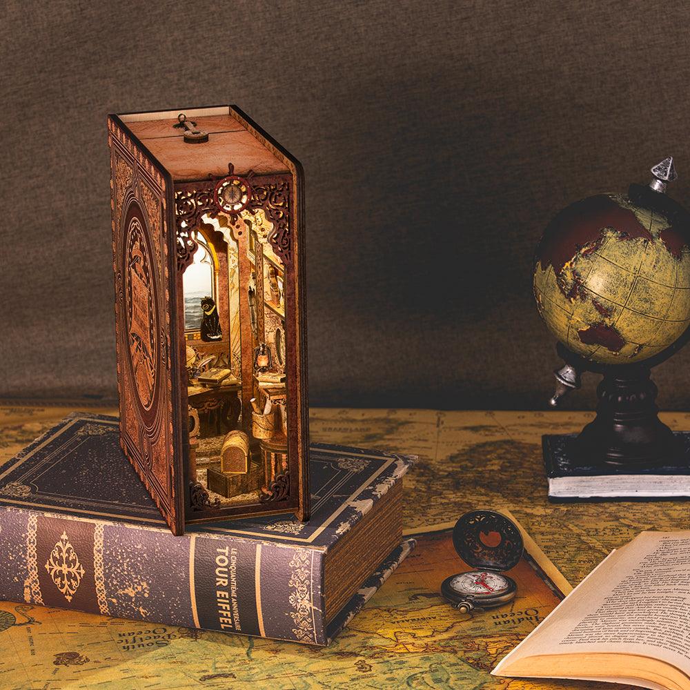 Nautical book nook shelf insert with carved wood exterior and a warm lit seafaring cabin beside a vintage globe
