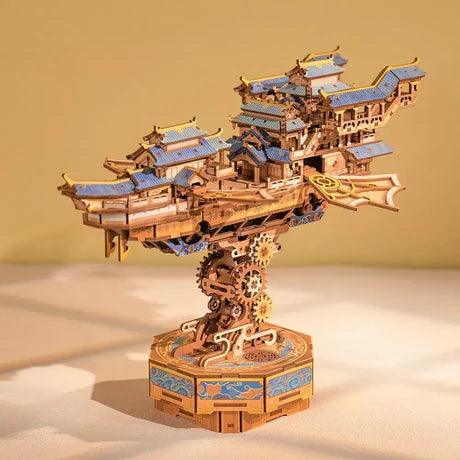 Sky Voyager laser cut wooden airship kit with layered pavilion roofs and a mechanical gear base for desk display