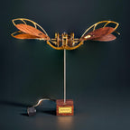 Kinetic 3D metal puzzle aircraft with motorized dragonfly wings as a mechanical desk sculpture and shelf centerpiece