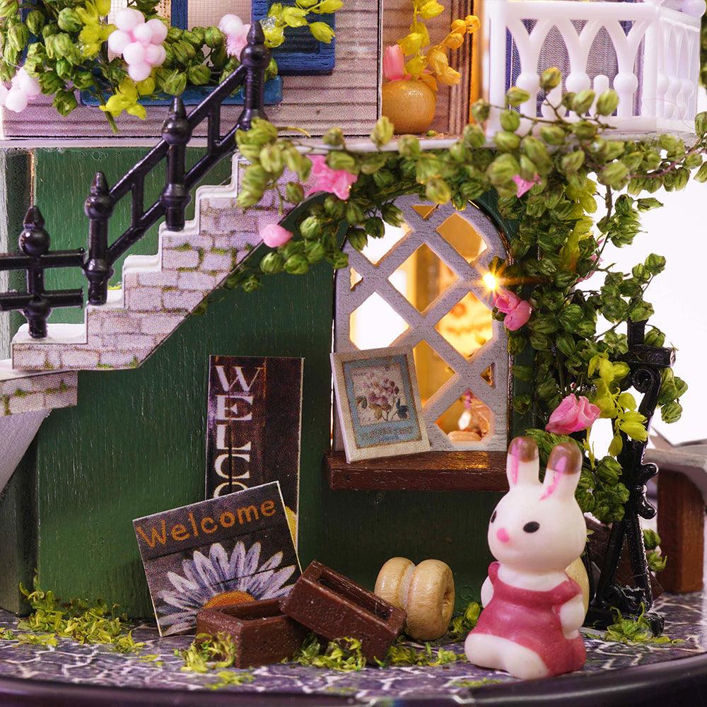 Miniature dollhouse garden entrance with climbing roses, a welcome mat and staircase for shelf and desk display
