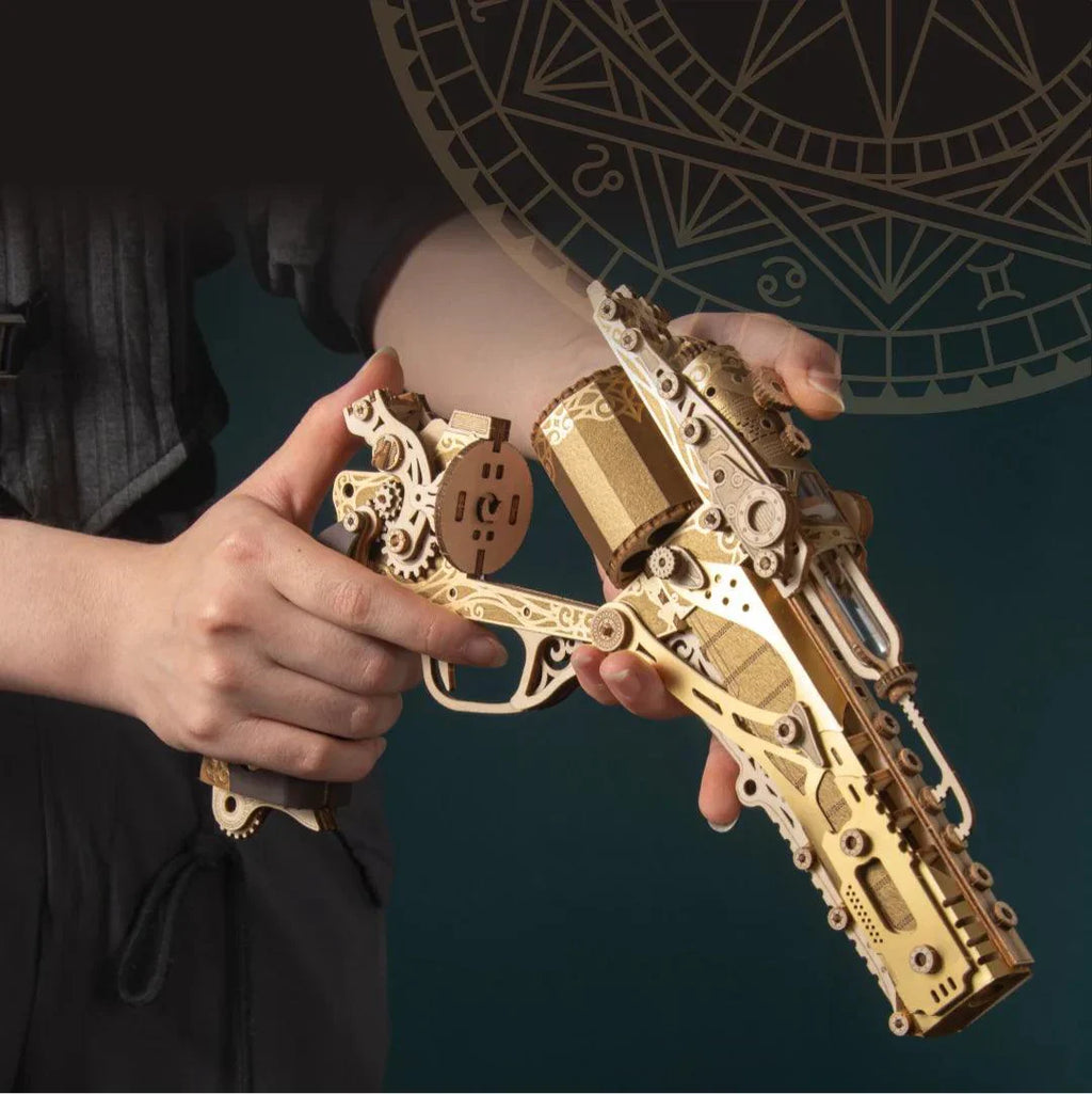 Gilded wooden revolver puzzle held in hand, a working trigger gun model and Victorian desk collectible for hobby builders Fantasy Luxury