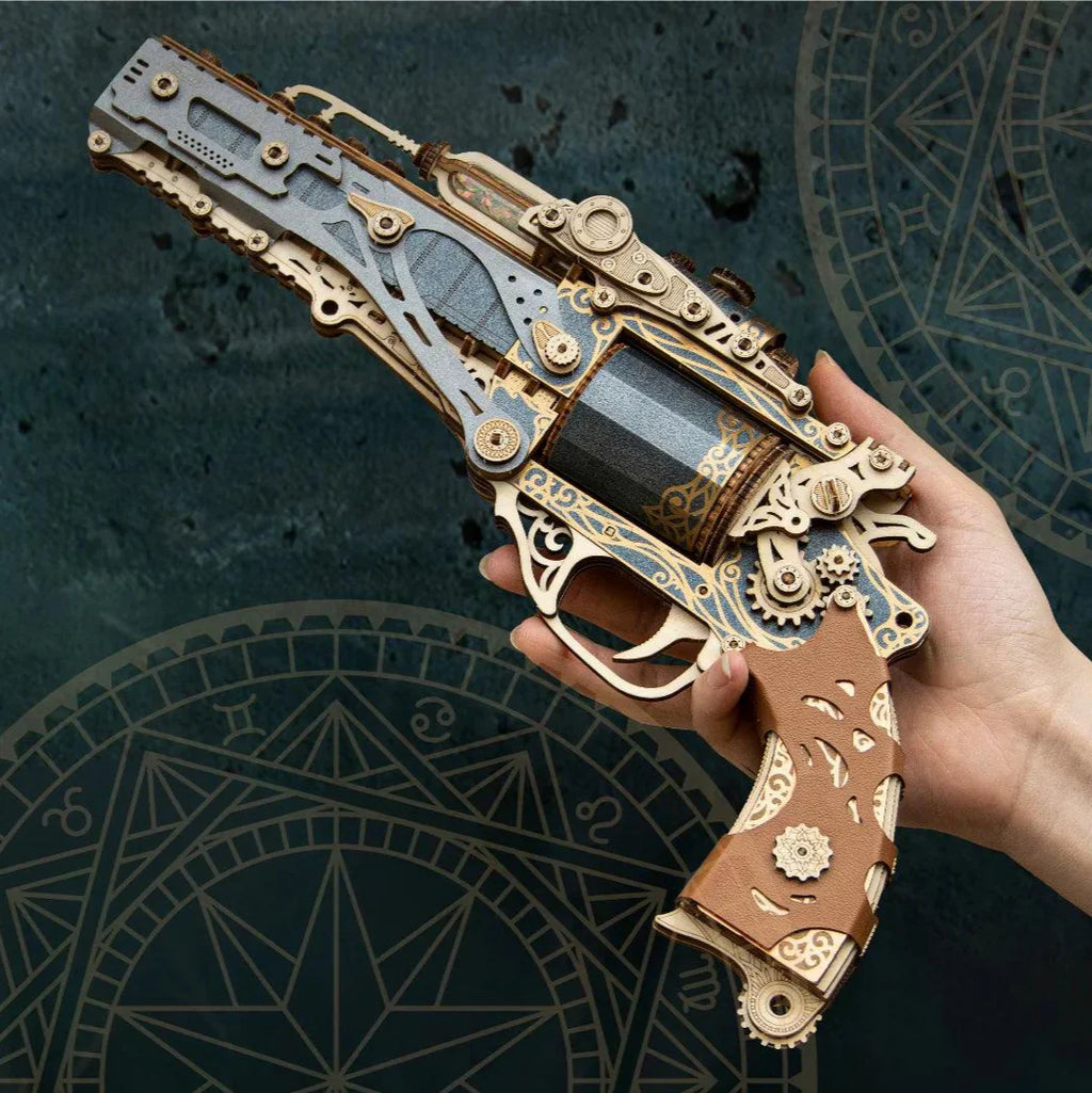 Steampunk revolver model kit shown in hand, a gunmetal wooden puzzle gun with moving parts for desk decor and for gifting Steampunk
