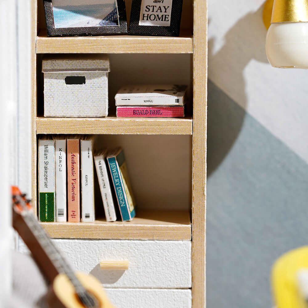 Furnished miniature bookshelf with tiny books and decor in a sunny modern dollhouse kit for hobbyists and collectors