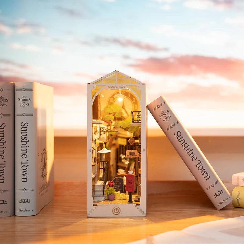 Miniature bookshop interior with two sleepy cats and a coffee corner glowing under a warm LED roof for cozy shelf decor