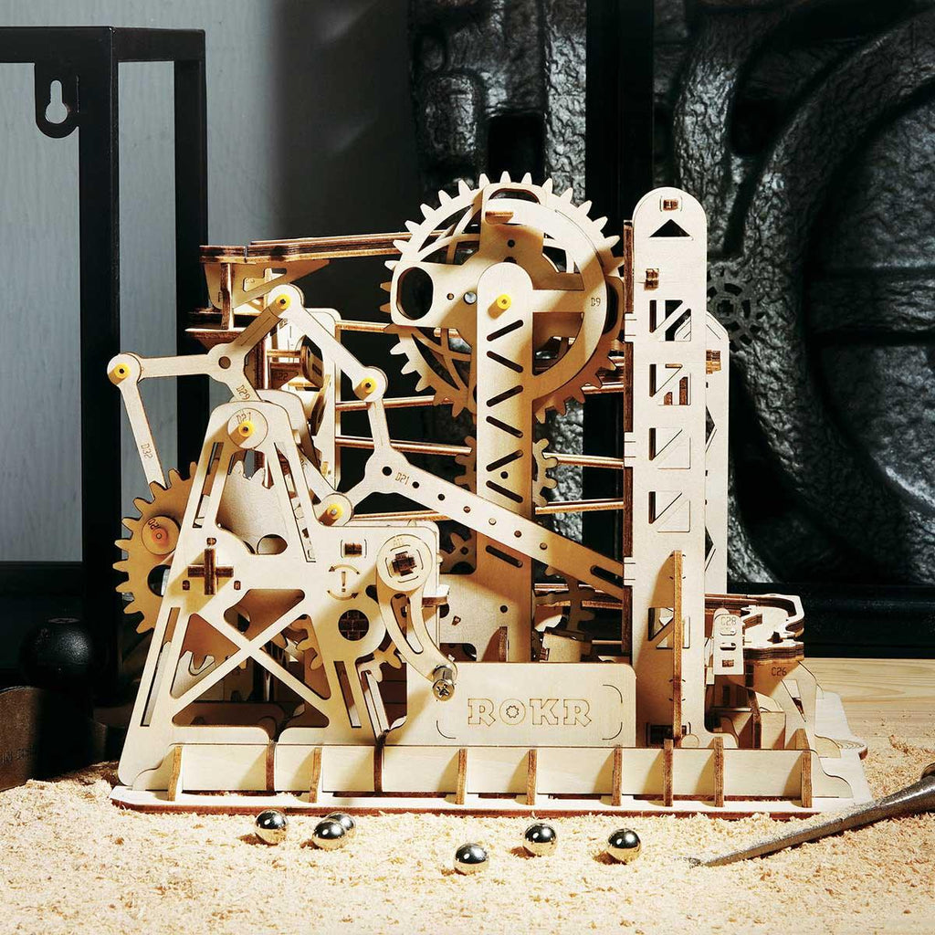 Wooden marble run with rotating gears and a crane elevator, a kinetic desk display and screen-free STEM build for teens